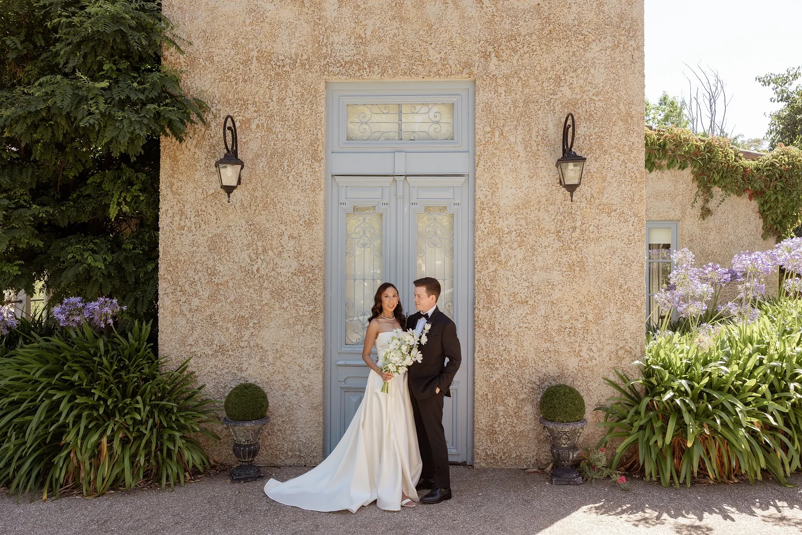 Bride and groom photographed outside a warm-toned villa