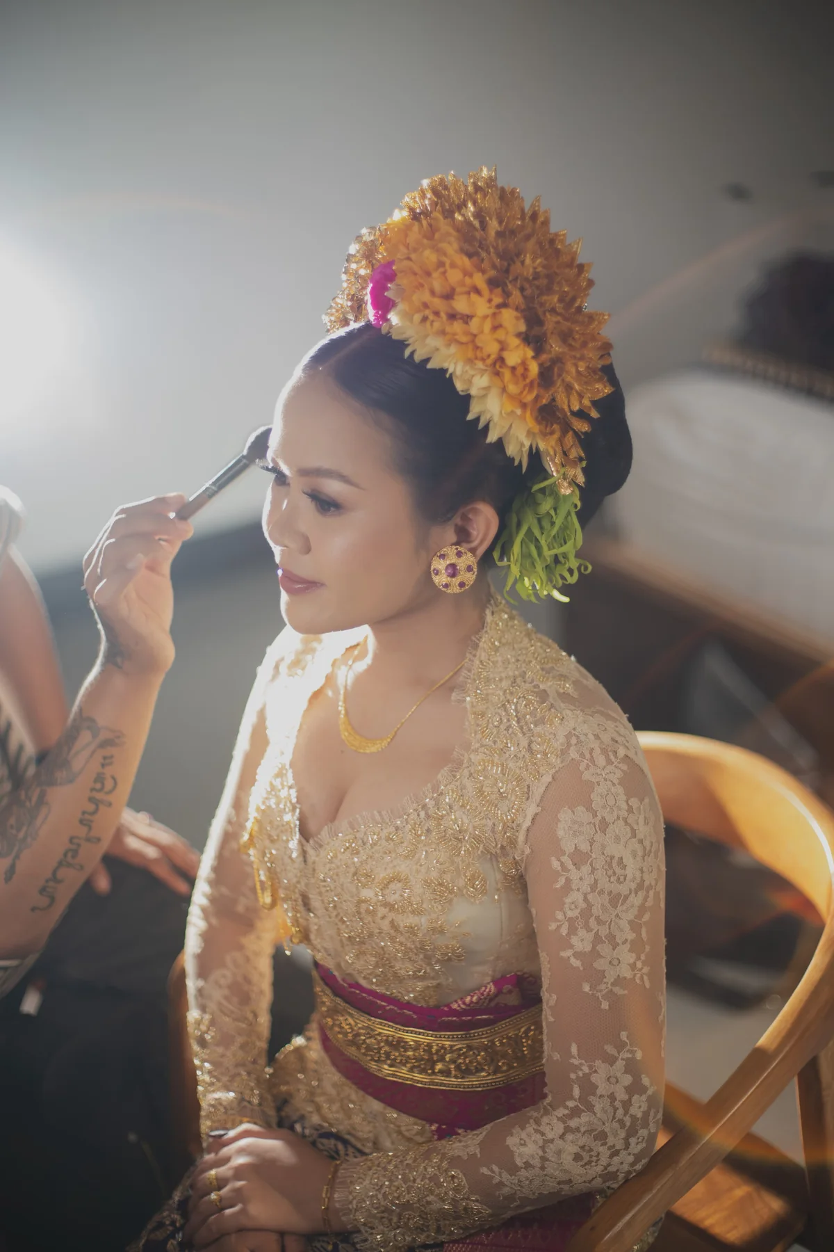 A bride having her eye makeup refined before the ceremony