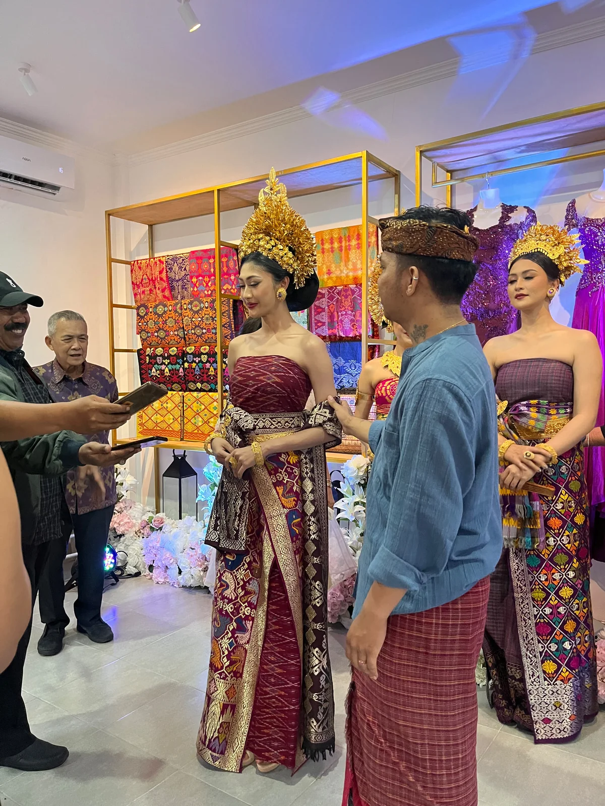 People discussing bridal presentation beside garments and traditional attire in the OSA studio