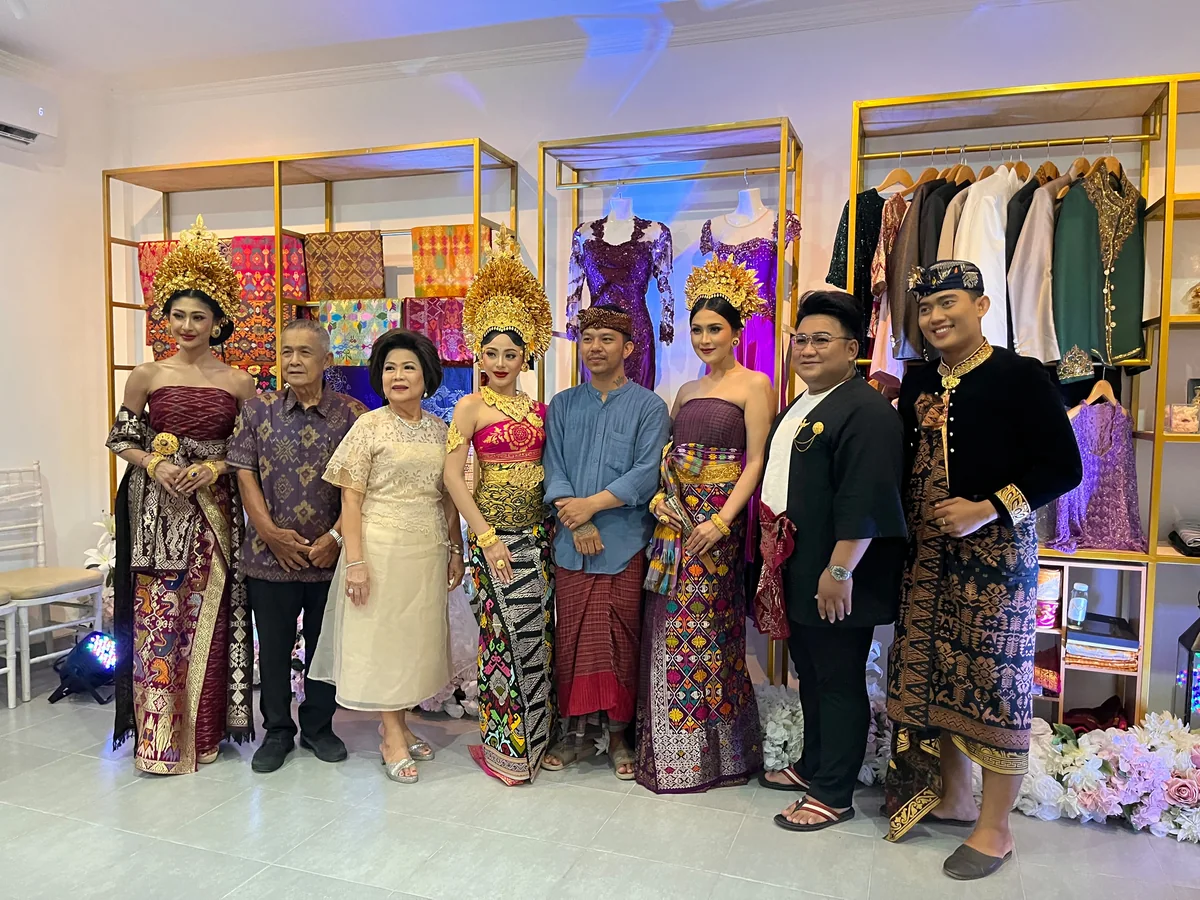 A group standing together with three women wearing traditional bridal attire in the OSA studio